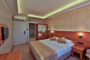a bedroom with a large bed and a tv at Seymen Hotel in Amasra