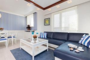 salon z niebieską kanapą i stołem w obiekcie Sailor Apartment Jastrzębia Góra by Renters Prestige w Jastrzębiej Górze
