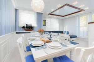 biała jadalnia z białym stołem i krzesłami w obiekcie Sailor Apartment Jastrzębia Góra by Renters Prestige w Jastrzębiej Górze