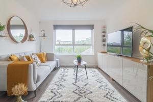 a living room with a couch and a tv at Luxury Glasgow Flat in the heart of the Westend in Glasgow