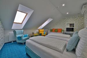 - une chambre avec 2 lits et des chaises colorées dans l'établissement Hotel Pod Bránou, à Bardejov