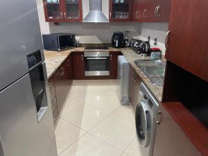 a small kitchen with a stove and a dishwasher at The Sails in Durban