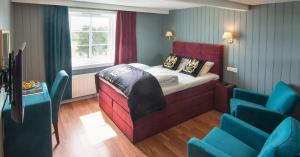 a room with a bed and blue chairs in it at Arendal Herregaard Spa & Resort in Arendal +44 photos