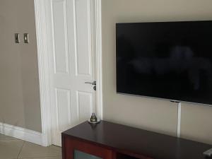 a flat screen tv on a wall next to a door at The Sails in Durban