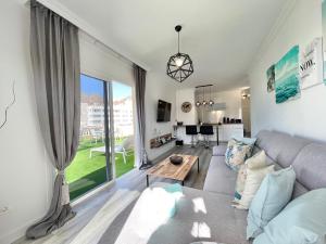 ein Wohnzimmer mit einem Sofa und einem Tisch in der Unterkunft PaulMarie Apartment Gigantes Ocean Lounge in Puerto de Santiago