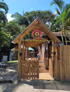 a wooden gazebo with a sign on it at Pousada Morada das Flores in Ilha do Mel