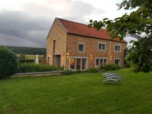 une maison en briques avec une pelouse devant elle dans l'établissement Gite rural '21 bonnes raisons' - Ossogne, à Havelange