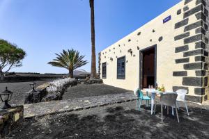 uma mesa e cadeiras em frente a um edifício em Petit La Geria Lanzarote em Tías