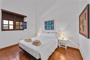 a bedroom with a bed and a table and a window at Petit La Geria Lanzarote in Tías