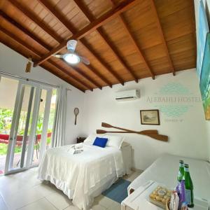 a bedroom with a bed and a table in a room at Alebahli Hostel Ilhabela ᵇʸ ᴬᴸᴱᴮᴬᴴᴸᴵ in Ilhabela