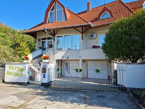 a house with a gate and a pay phone in front of it at Balaton Holiday in Fonyód