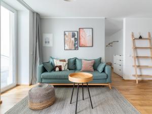 ein Wohnzimmer mit einem grünen Sofa und einem Tisch in der Unterkunft limehome Leipzig Jahnallee in Leipzig