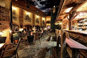 a restaurant with tables and chairs and a bar at Hotel Pod Bránou in Bardejov