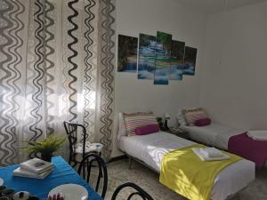 Zimmer mit 2 Betten, einem Tisch und Stühlen in der Unterkunft Bnbook-L'appartamento di Gio' in Rho