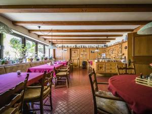 a restaurant with purple tables and chairs and a kitchen at Hotel- Pension Oechsner in Bad Reichenhall