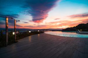 een zonsondergang over een loopbrug met een zwembad met water bij Hotel dP Olbia - Sardinia in Olbia