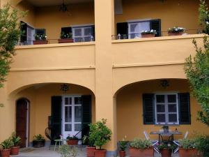 un immeuble d'appartements avec un balcon orné de plantes en pot dans l'établissement Bed&Breakfast Villa Camilla, à Ivrea