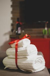 einen Stapel Handtücher mit einem roten Band in der Unterkunft Frizzi & Lazzi House in Neapel