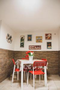 a dining room with a white table and red chairs at Frizzi & Lazzi House in Naples