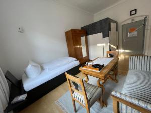 ein kleines Zimmer mit einem kleinen Tisch und einem Bett in der Unterkunft Bischöfliches Seminar St. Willibald in Eichstätt