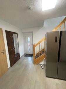 ein leeres Zimmer mit einem Kühlschrank und einer Treppe in der Unterkunft Haus 13 zum Südblick in Garnbach