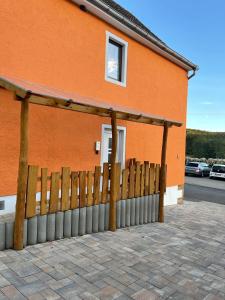 a building with a wooden fence in front of it at Haus 13 zum Südblick in Garnbach