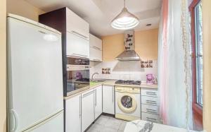 a kitchen with white cabinets and a washer and dryer at Апартаменты 10-й микрорайон, 5А in Almaty