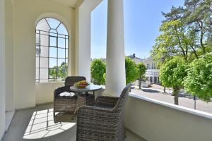 d'une terrasse avec 2 chaises et une table sur un balcon. dans l'établissement Ferienwohnung 1 Villa Celia Sellin, à Sellin