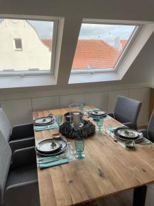 a dining room table with plates and glasses on it at Loft Sternenblick in Lüdinghausen