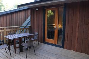 a patio with a table and chairs on a deck at Five Elements Lodge B&B with Outdoor Spa in Fernwood