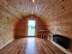 a wooden room with a window and a table in it at Eastridge Glamping - Camping Pods in Shrewsbury