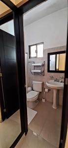 a bathroom with a toilet and a sink at Departamentos X`Kanlol in Izamal