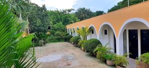 a building with a row of plants in front of it at Departamentos X`Kanlol in Izamal