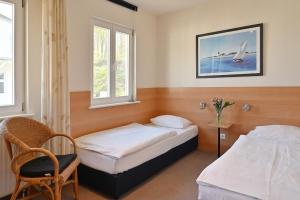 - une chambre avec 2 lits, une chaise et des fenêtres dans l'établissement Ferienwohnung 13 Villa Celia Sellin, à Sellin