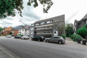 a row of cars parked in front of a building at Harmony Apartment in Gelsenkirchen
