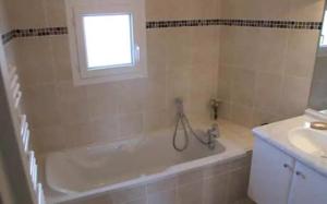 een badkamer met een bad en een wastafel bij Casa Del Mar - Beautiful Two Bedroom Penthouse Apartment in Sainte-Maxime +29 foto's