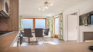 a dining room with a table and chairs and windows at Pension Riese in Neustift im Stubaital
