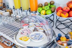 a buffet with bowls of fruit and drinks on a table at Hotel Gabbiano in Rimini