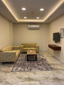 een woonkamer met een bank en een tafel bij شقق القارات السبع الاحساء in Al Hofuf