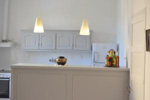 a kitchen with white cabinets and a counter with bottles at Tsartsada house in Áno Lefkímmi