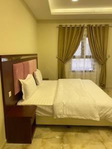 Un dormitorio con una cama grande y una ventana en شقق القارات السبع الاحساء, en Al Hofuf