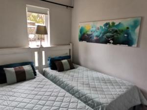 a bedroom with two beds and a painting on the wall at The Bridge nr 13 in St Lucia