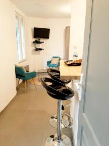 a living room with a bar stool in a room at Le Petit Charmeur, parking, Wifi, gare in Flers
