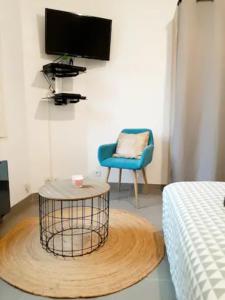 a room with a bed and a table and a chair at Le Petit Charmeur, parking, Wifi, gare in Flers