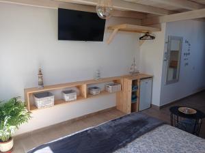 una camera da letto con una tv a parete e un letto di Mar&dunas a La Oliva