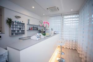 a white kitchen with a counter and a window at Hotel Gabbiano in Rimini