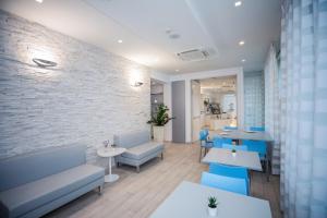 a restaurant with blue chairs and tables and a brick wall at Hotel Gabbiano in Rimini