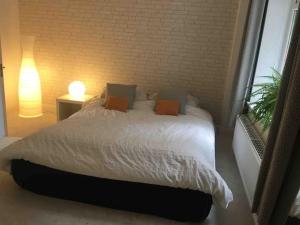 a bedroom with a bed with white sheets and orange pillows at Chartleigh in Southampton