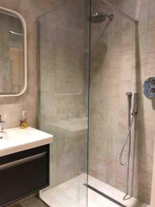 a shower with a glass door next to a sink at Chartleigh in Southampton