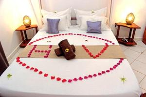 a bed with a teddy bear made out of hearts at Hotel Vanivola in Sainte Marie